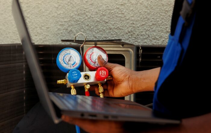 Seasoned mechanic restoring cooling capacity of air conditioning system by removing existing refrigerant, inspecting system for leaks and recharging with new freon to prevent damage to compressor